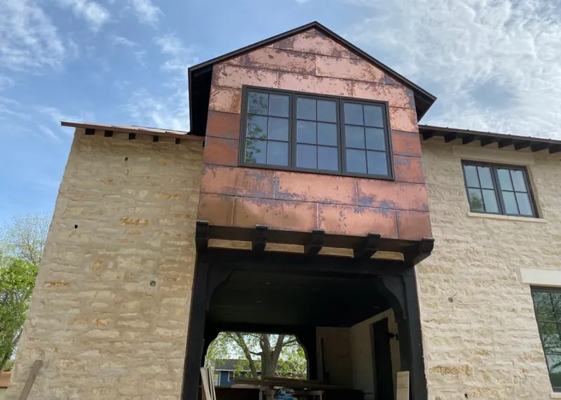 Copper metal panel facade on a stone building for Roof Repair in Patton
